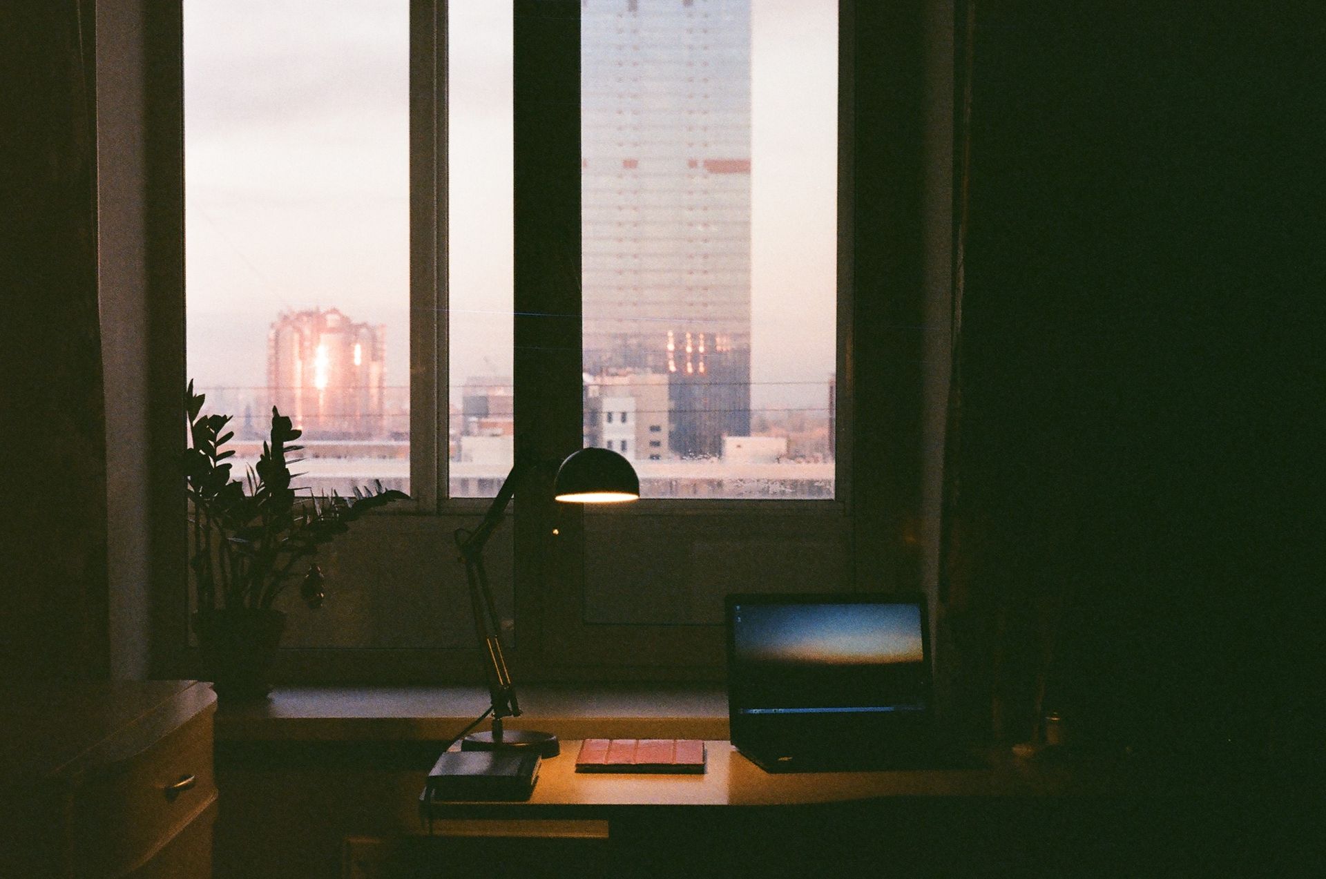 Laptop desk overlooking a city skyline at dusk